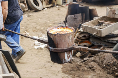 Worker carrying molten iron in container at factory