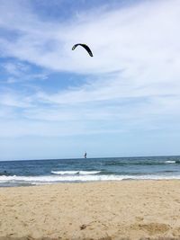 People at beach against sky