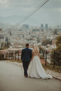 Rear view of couple standing on bridge