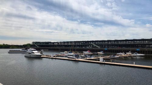 View of marina at harbor against cloudy sky