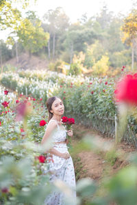 Portrait of young woman standing on field