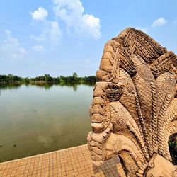 Sculpture of buddha statue against cloudy sky