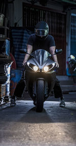 Man starting up his motorcycle in dark alley in bangkok