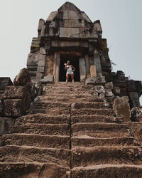 Low angle view of woman standing outside temple against clear sky