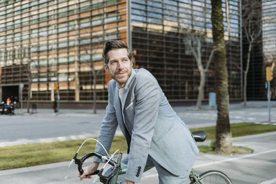 Man riding bicycle on road in city