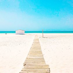 Pier on beach against sky