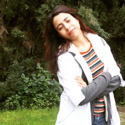 Beautiful young woman standing against plants