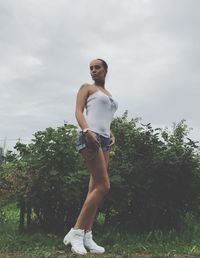 Portrait of woman standing against trees