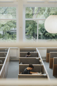 High angle view of male and female students studying in library