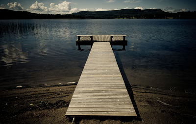 Pier on lake against sky