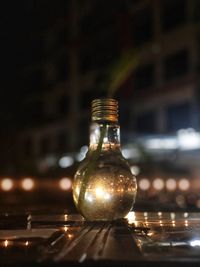 Close-up of illuminated light bulb on table