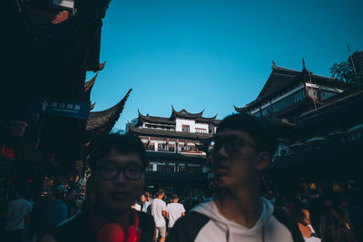 People in front of buildings against sky