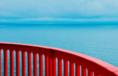 Abstract view of red railing against blue sea 