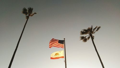 Low angle view of american and california flags