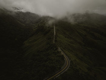 Countryside road passing through the lush green tropical rain forest mountain landscape