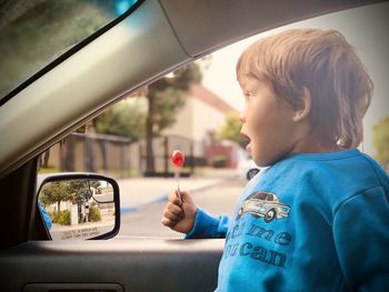 Smiling boy eating candy in car