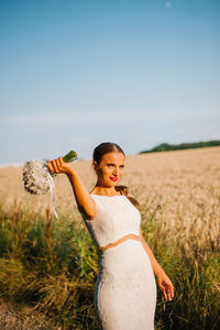 Full length of woman standing on field against sky