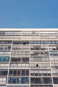 Low angle view of office building against blue sky