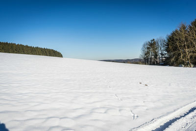 Scenic view of snowy landscape against clear sky