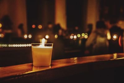 Close-up of illuminated tea light candle on table