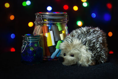 Close-up of stuffed hedgehog by jars