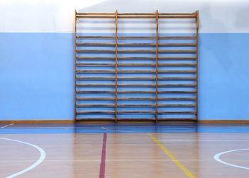 Wooden wall bars in the big empty gym without the athletes