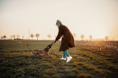 Full length of a dog on field during sunset