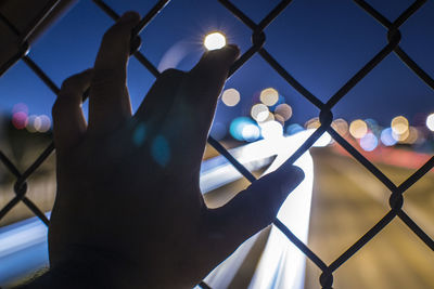 Close-up of hand against sky at night