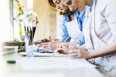 Inspired women drawing on fabric in workshop