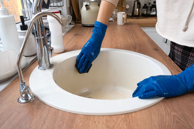 Cropped image of woman washing hands in bathroom