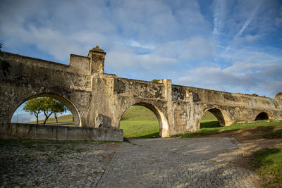 Arch bridge over river against sky