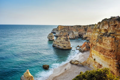 View from above of the marinha beach. only one couple walks on the sand.  algarve, portugal