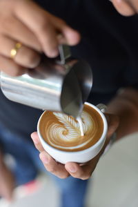 Close-up of hand holding coffee cup