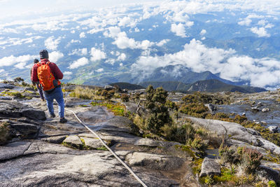 Rear view of man standing on rock