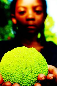 Close-up portrait of woman holding leaf