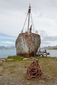 Abandoned ship on beach against sky