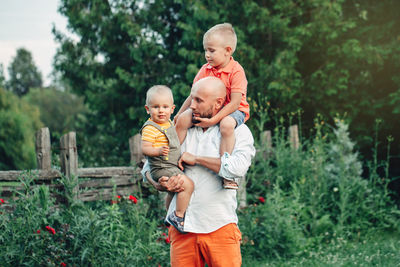 Full length of father and boy standing on plants