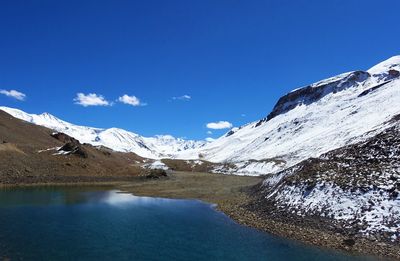 Scenic view of snowcapped mountains against clear blue sky