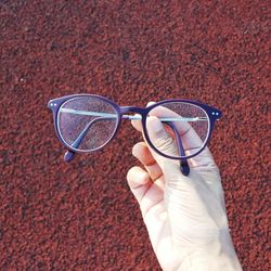 Close-up of hand holding sunglasses