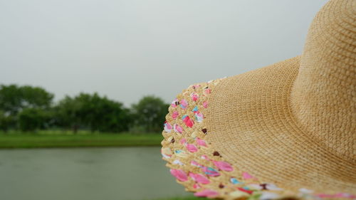 Close-up of pink hat by lake against sky