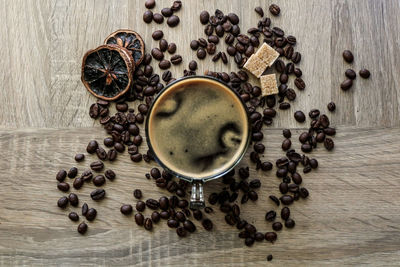 Directly above shot of coffee with beans on wooden table