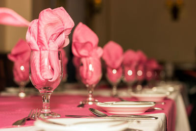 Wineglasses with napkins arranged on table at restaurant