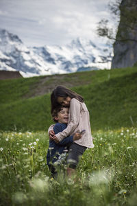 Side view of woman on field against mountain