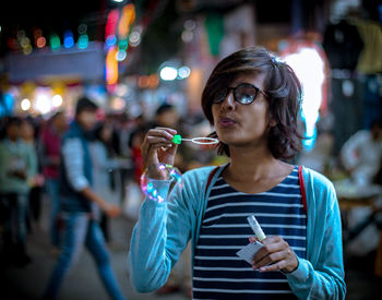 Close-up of woman blowing bubbles