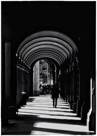 Rear view of people walking in corridor of building