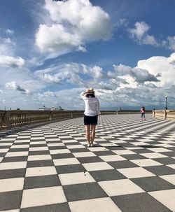 Full length of woman standing on floor against sky