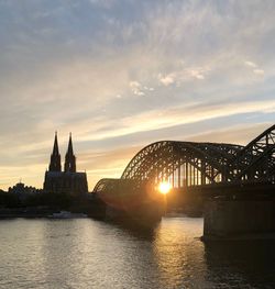 Bridge over river at sunset