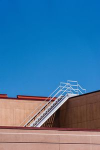 Low angle view of staircase against clear blue sky