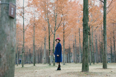Woman standing on tree trunk