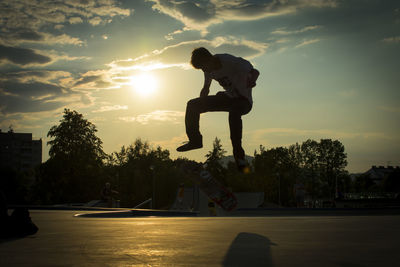 Man jumping against sky during sunset